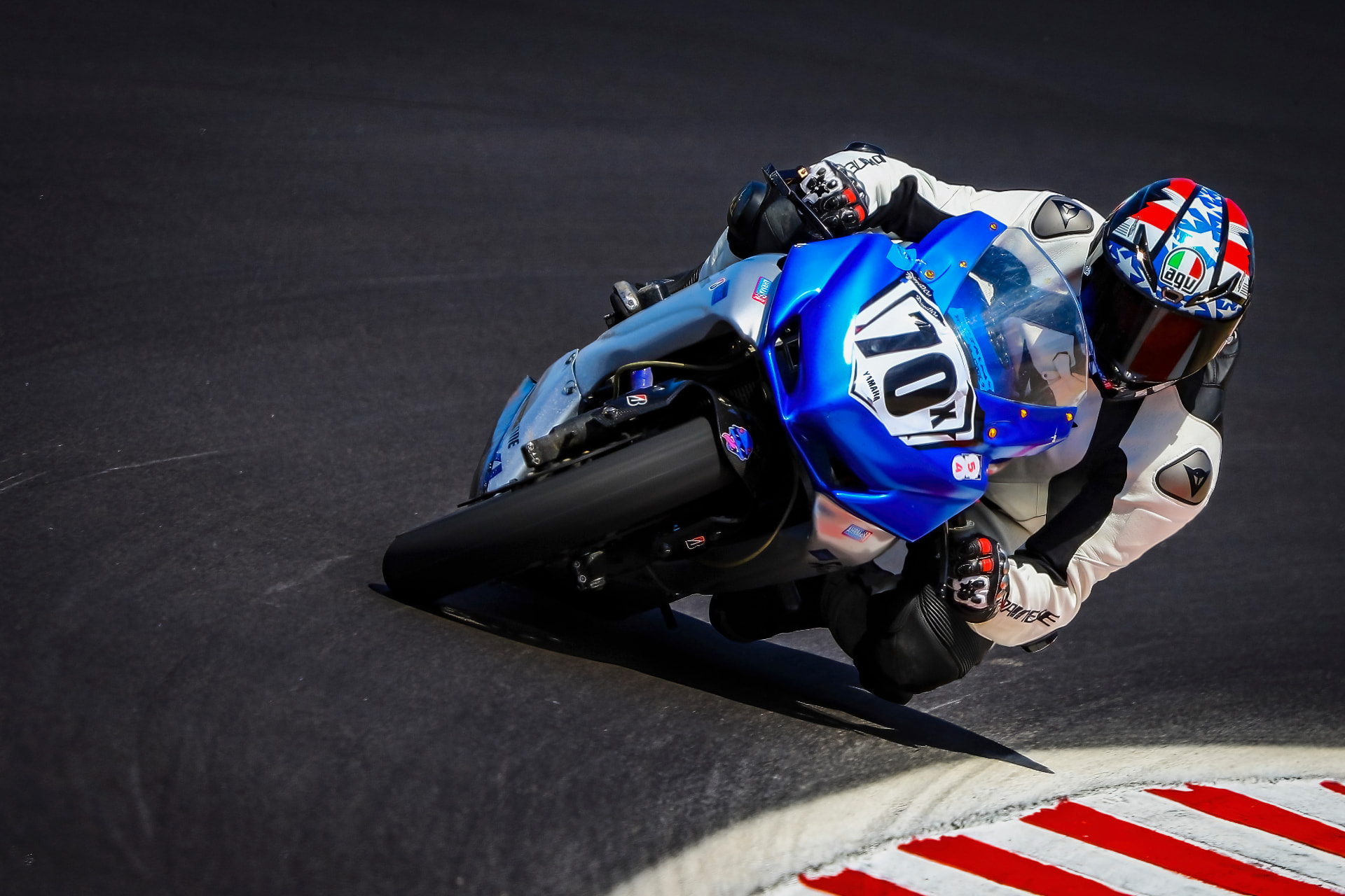 Joel Powell leaning through a corner on a blue #703 motorcycle