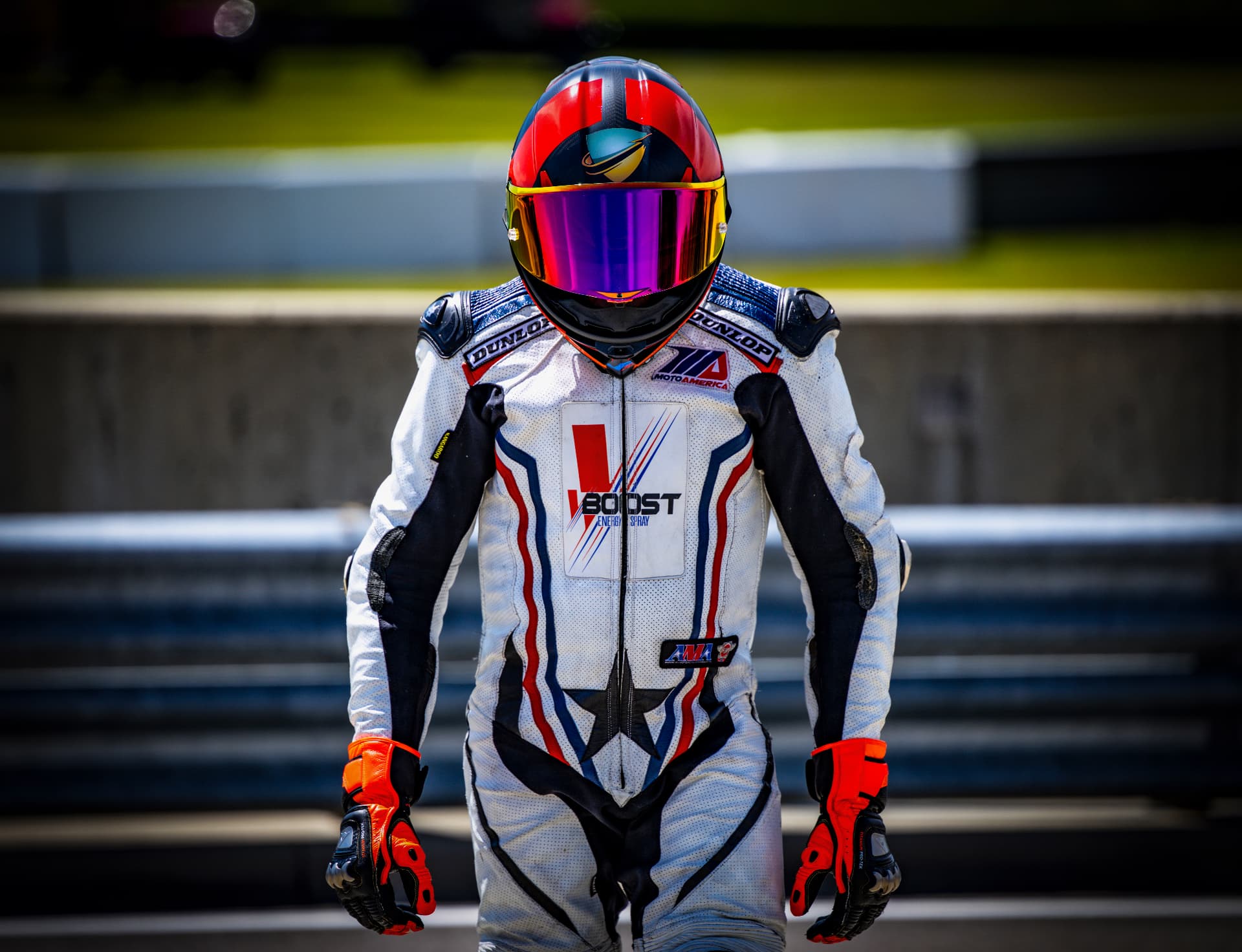Joel Powell in his racing leathers and helmet, standing trackside